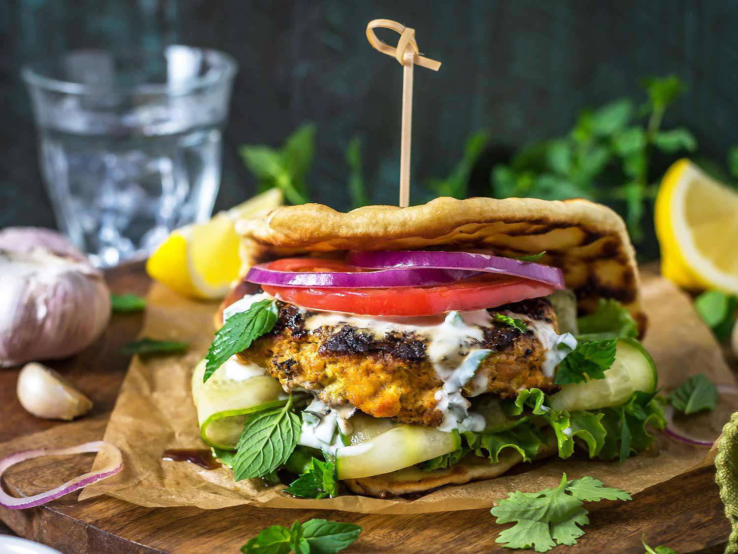 Grilled tandoori chicken patties sandwiched with grilled naan yogurt sauce, red onion, tomato, cucumber, and herbs