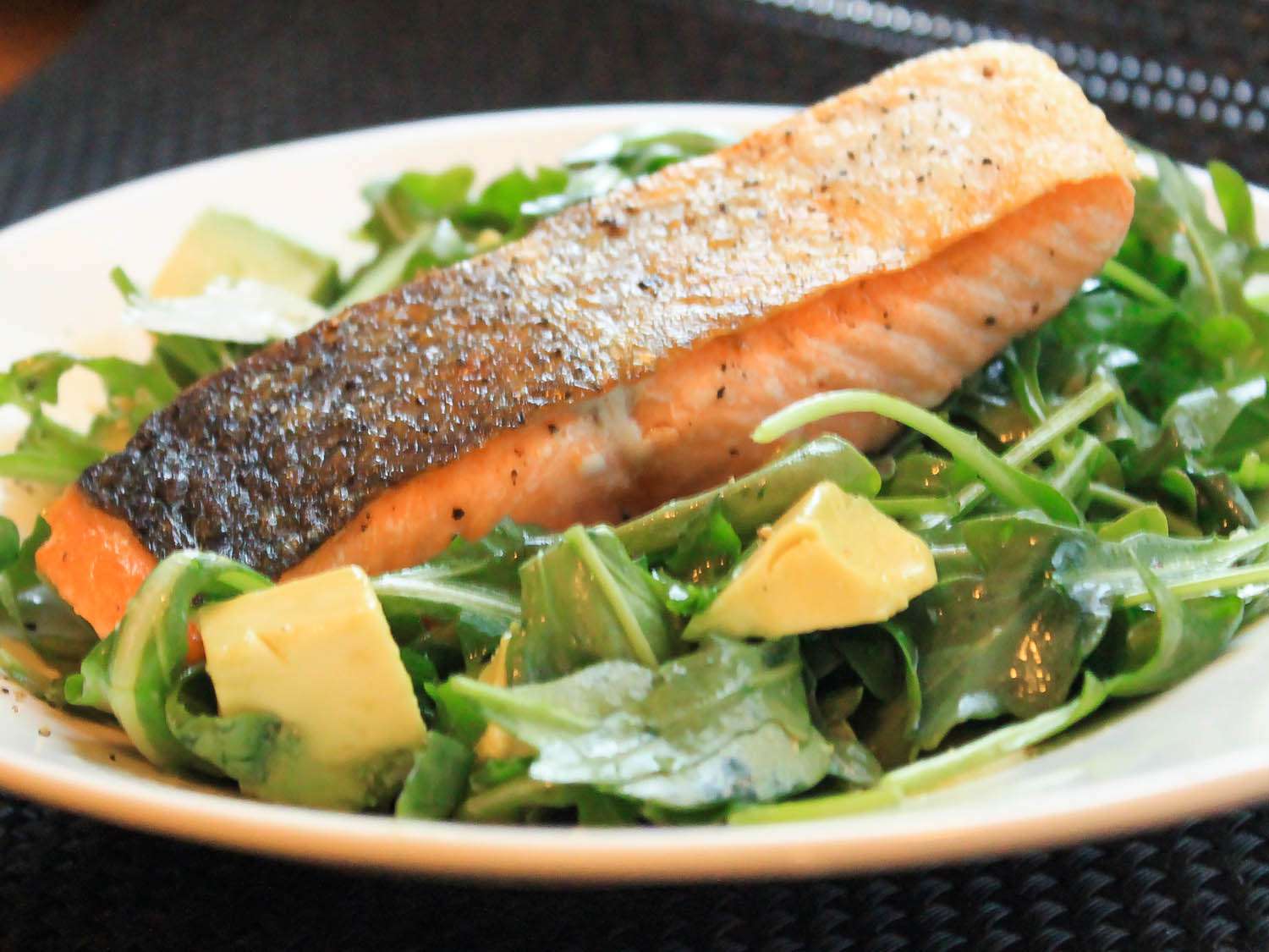 pan-roasted salmon on bed of arugula salad with avocado chunks