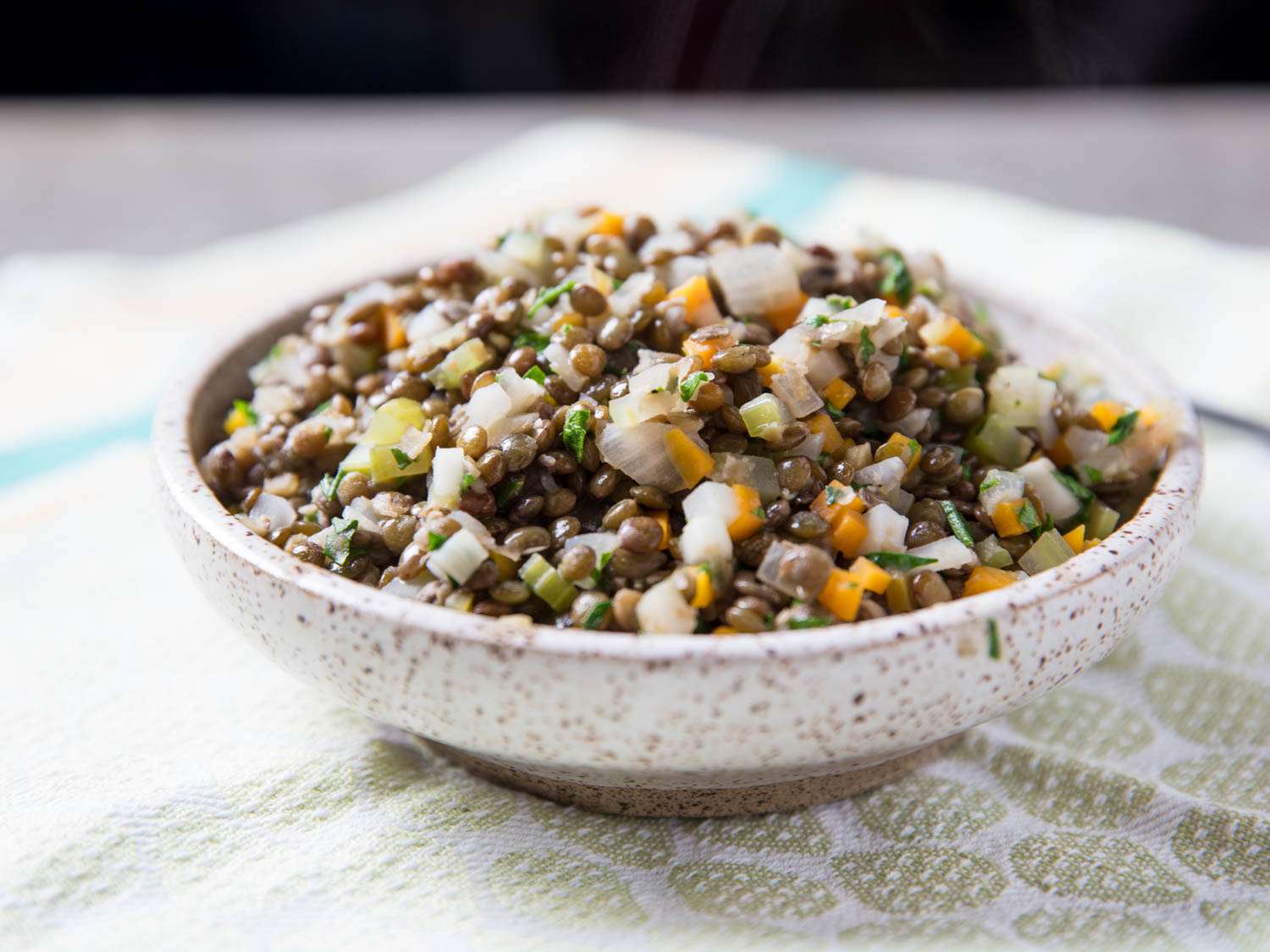 A bowl of French lentils with carrot, celery, onion, garlic and herbs