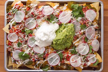 An overhead shot of the ultimate fully loaded nachos with sour cream and guac