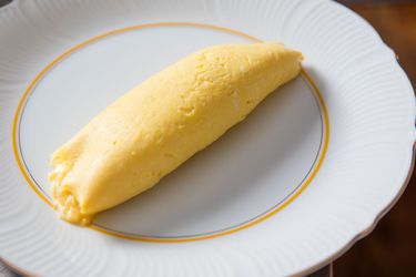 经典的法式煎蛋卷放在优雅的白色盘子上。