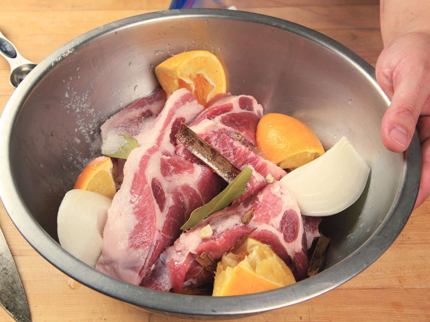 猪肉用洋葱、大蒜、肉桂、月桂叶和橙子四等分腌制
