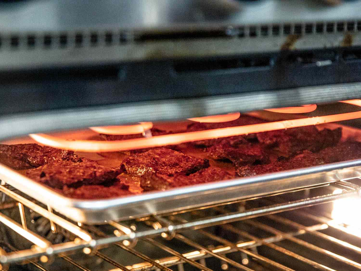 把牛排放在带边的烤盘上，放在烤箱的热烤炉上;烤箱架在最高的位置