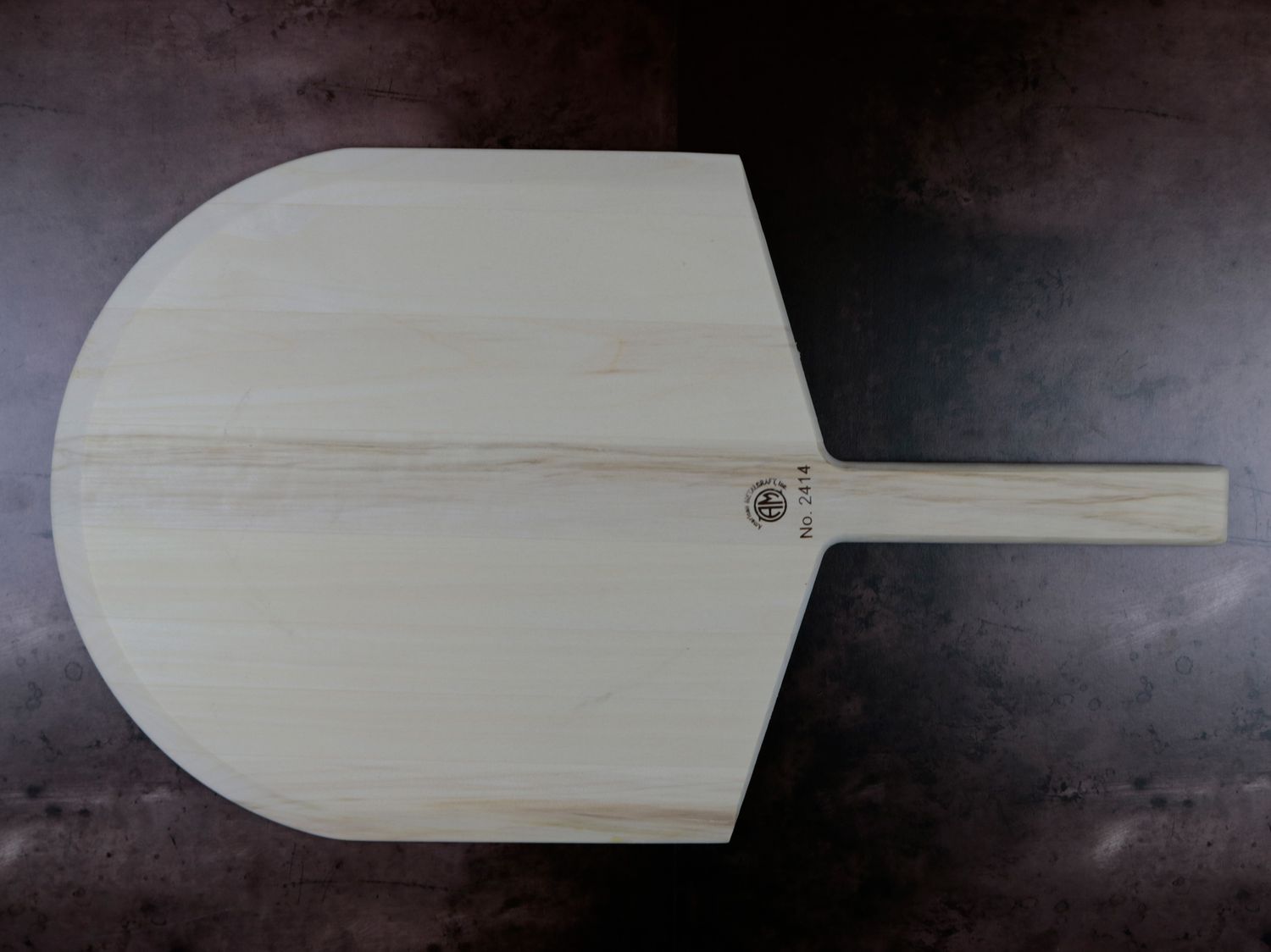 a wooden pizza peel on a dark background