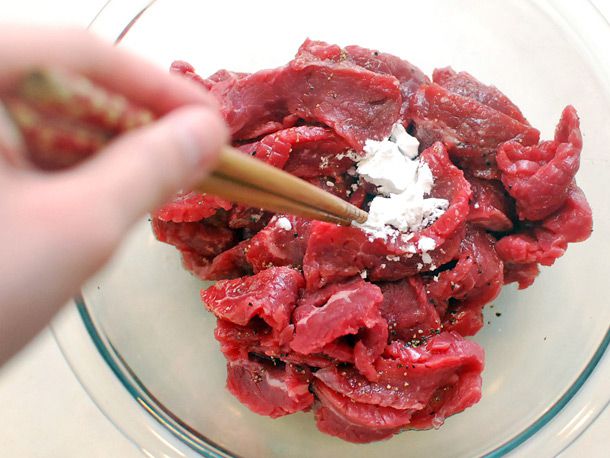 将生牛肉片放入玻璃碗中，浇上玉米淀粉，用一双筷子将食材混合在一起。华体会应用下载