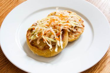 Two cheese and bean pupusas topped with cabbage slaw