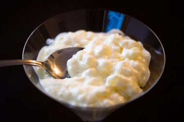 Tapioca pudding, served in a small black bowl.