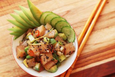 Hamachi poke with cucumber and avocado, served in a small bowl.