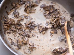 A creamy mushroom pan sauce is stirred in a skillet.