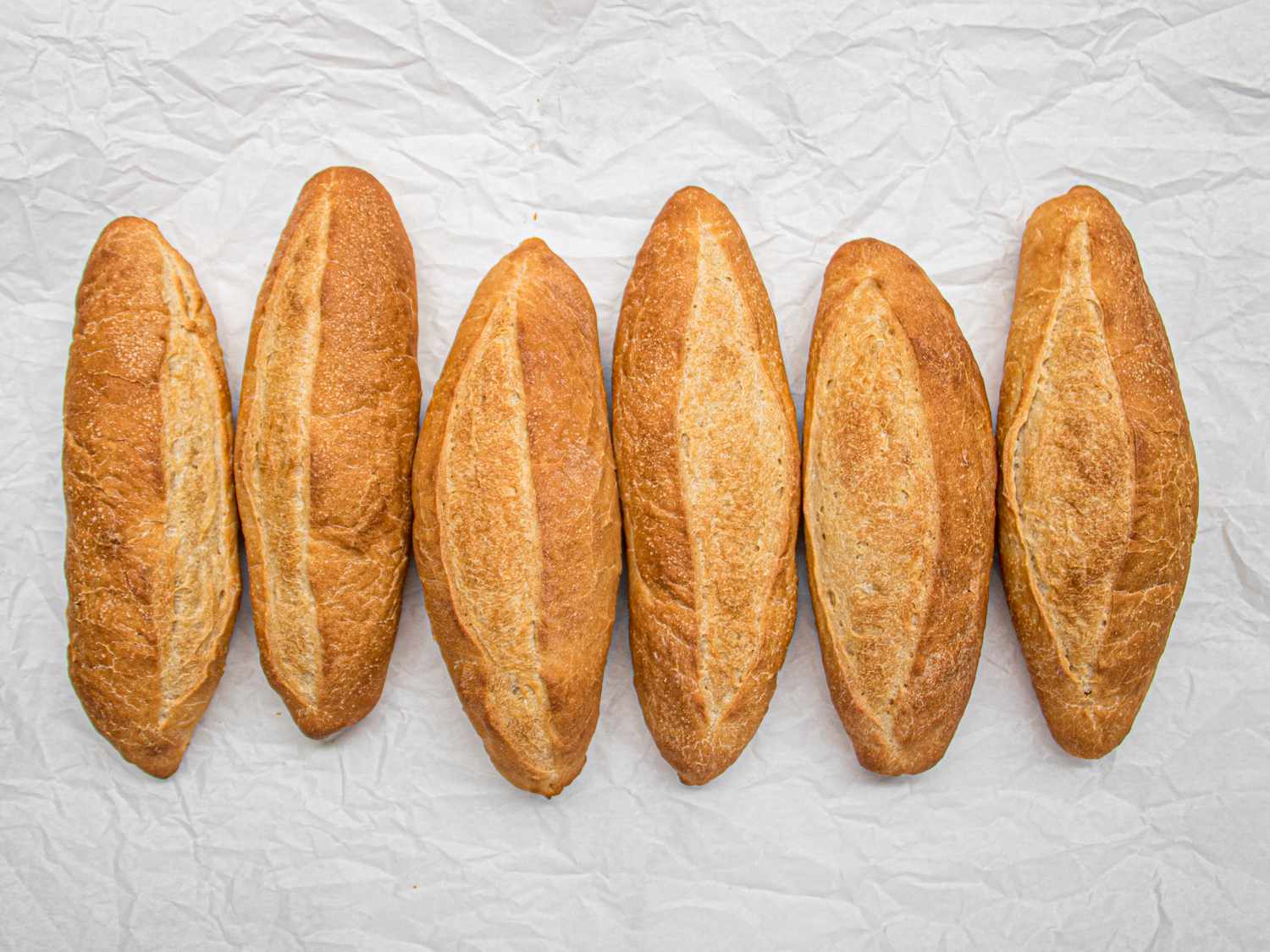 Six banh mi bread loaves in a line