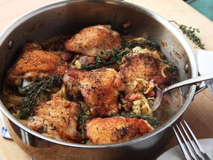 用不锈钢锅炖鸡腿配卷心菜和培根。