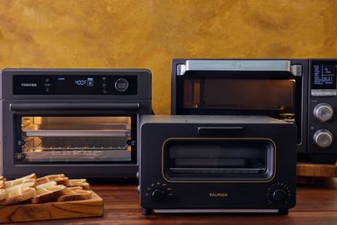 Three air fryer toaster ovens on a wooden countertop