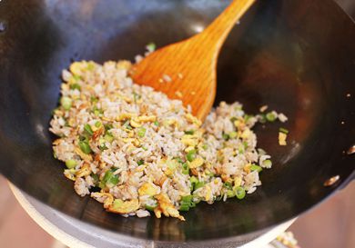 鸡蛋炒饭，用木勺在锅里搅拌