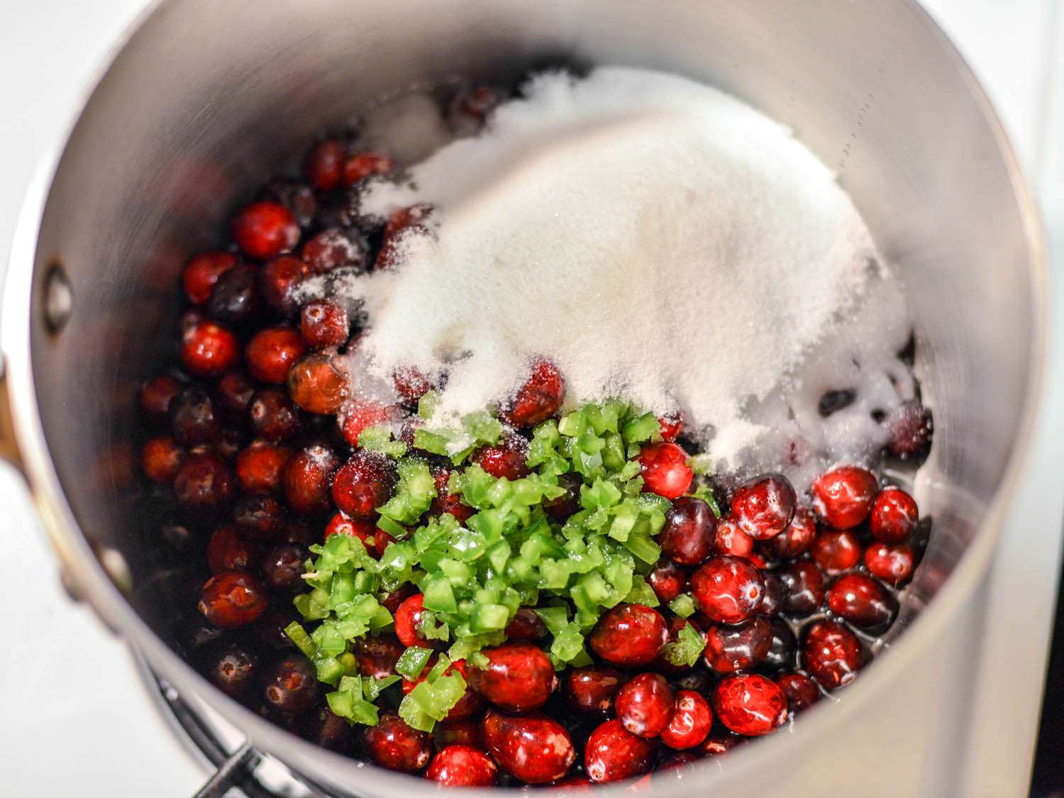 华体会应用下载在平底锅中制作蔓越莓酱的材料:蔓越莓，糖，酸橙汁和酸橙皮，还有水。