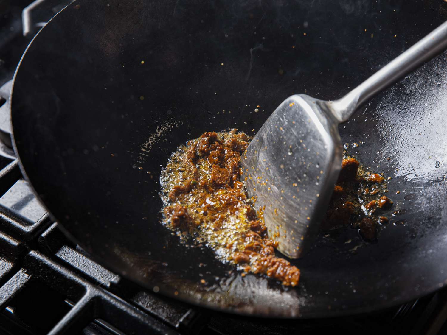 在锅里用金属铲在油里搅动咖喱