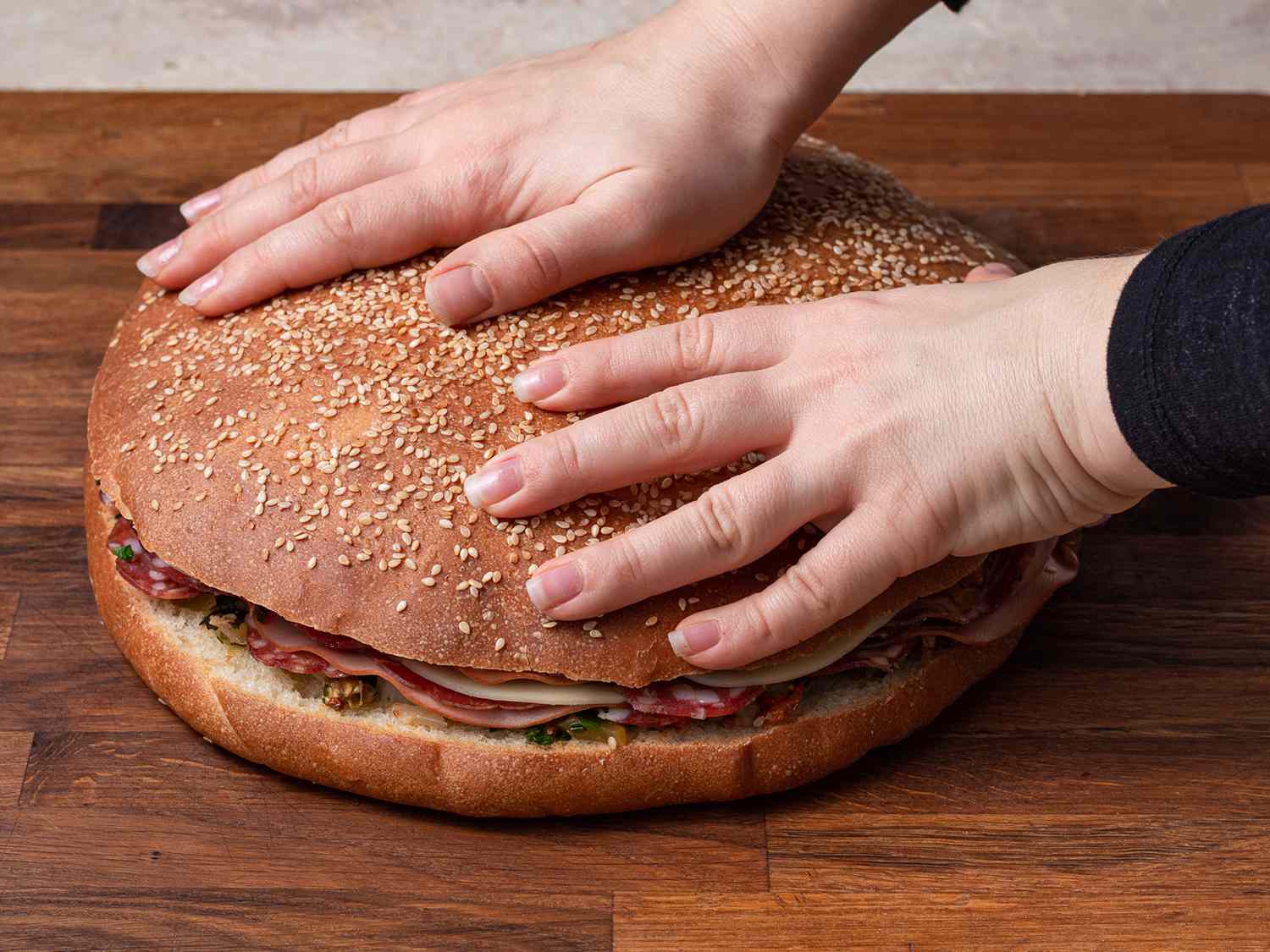马夫莱塔面包上面有两只手，这有助于显示它非常大。