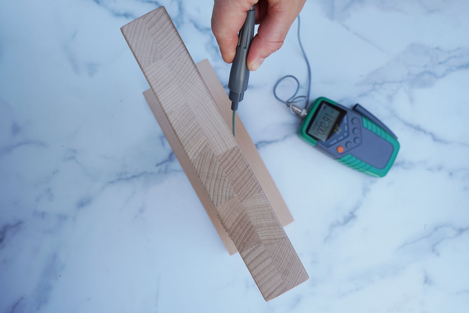 a person using a guass meter to measure the magnetic field of a knife block