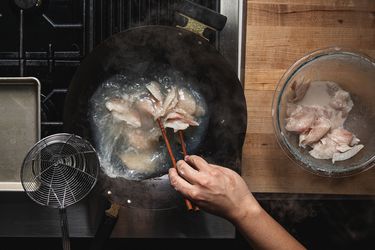 Overhead view of passing-through fish in a wok