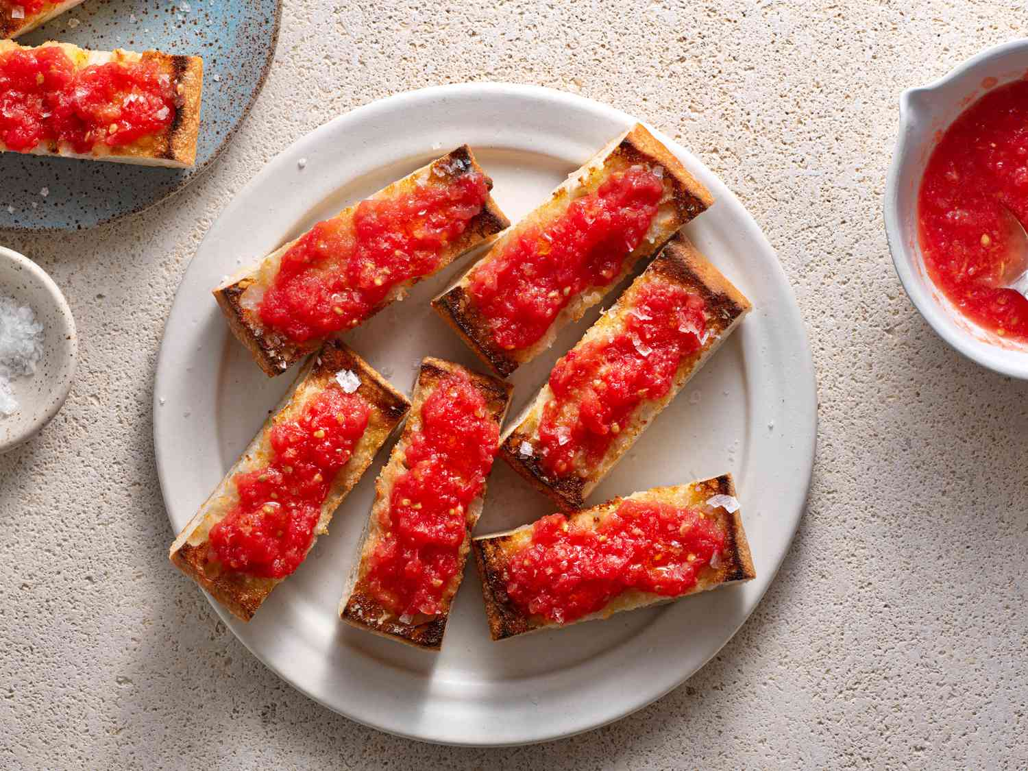 Pan Con Tomate (Spanish-Style Grilled Bread With Tomato) on a white ceramic plate.