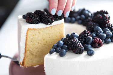爵士ving up a slice of chiffon cake with cream and berries