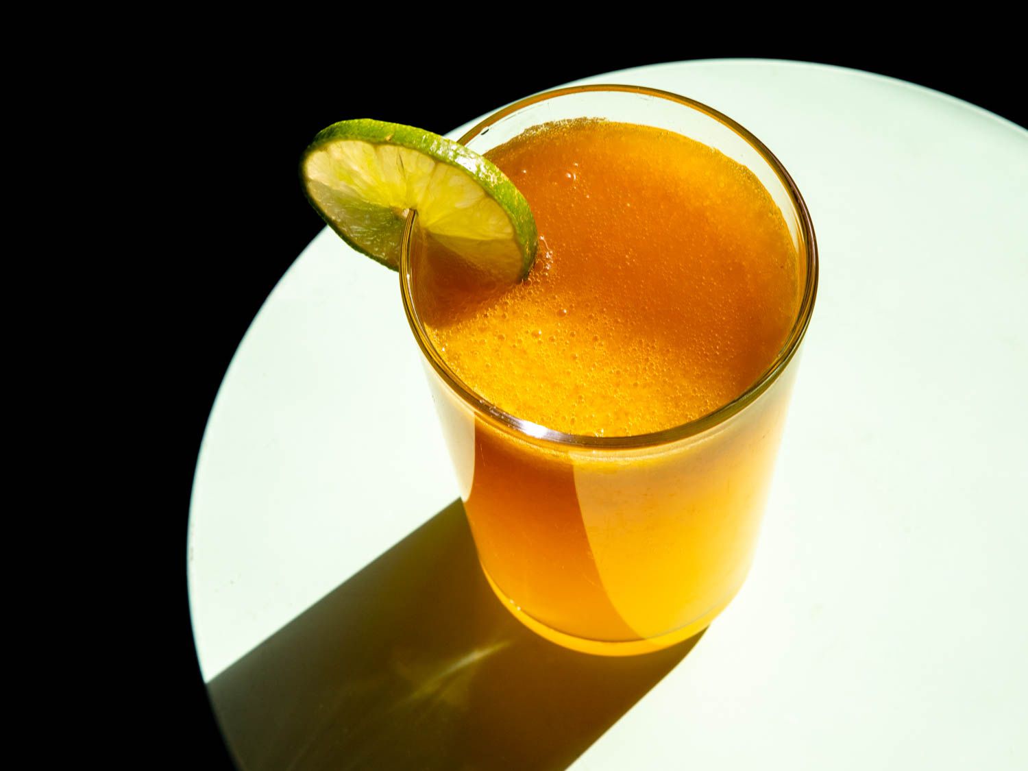 在柯林斯杯中加入姜和墨西哥胡椒的芒果糖，杯口有酸橙轮。