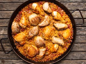 Grilled chicken and pork paella in a paella pan