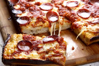 Detroit-style pepperoni pizza resting on a cutting board