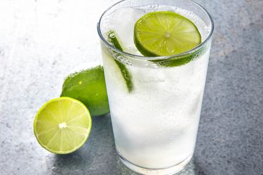 A sweating glass of cold nimbu soda with large slices of fresh lime