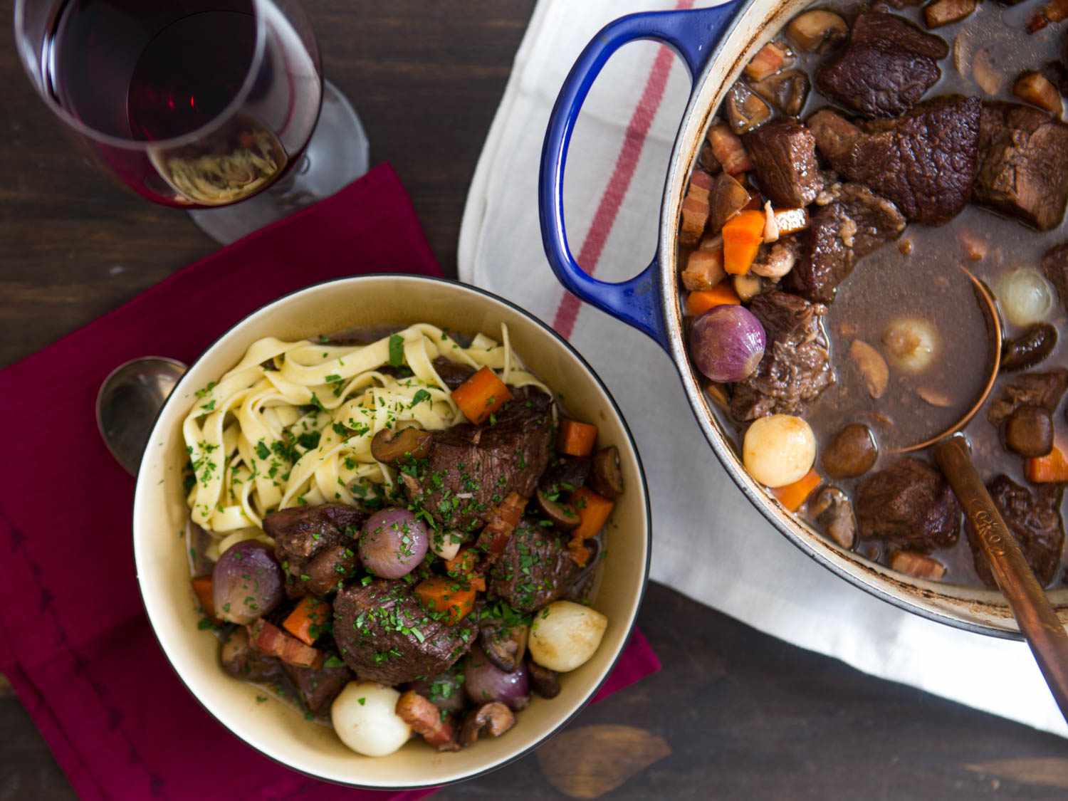 Overhead shot of a bowl of boeuf bourguignon dished out from a Dutch oven.
