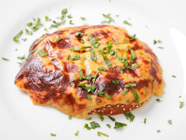 Closeup of Spammish rarebit, served on a white plate with a sprinkle of chopped parsley.