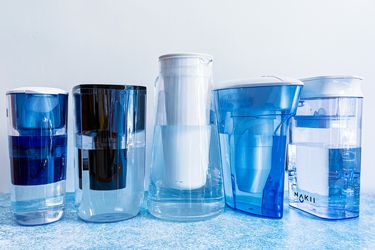 the lineup of water filter pitchers on a blue countertop