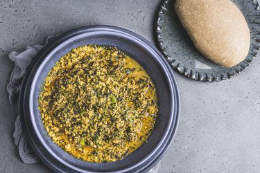 A full bowl of egusi soup served with a serving of eba.