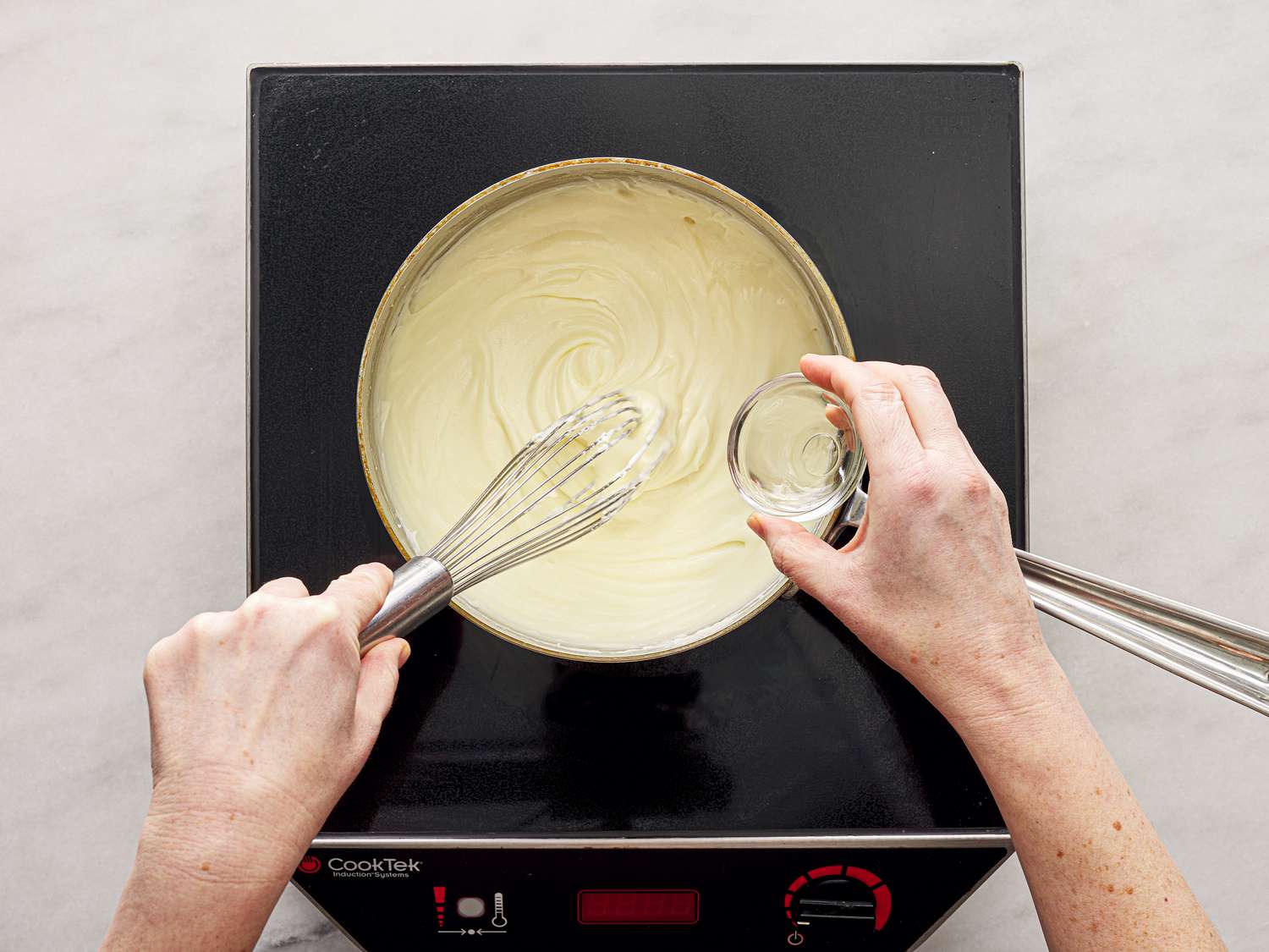 Adding rose water to custard mixture