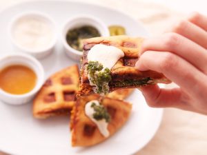 Waffled falafel sandwich dipped in tahina and green hot sauce.