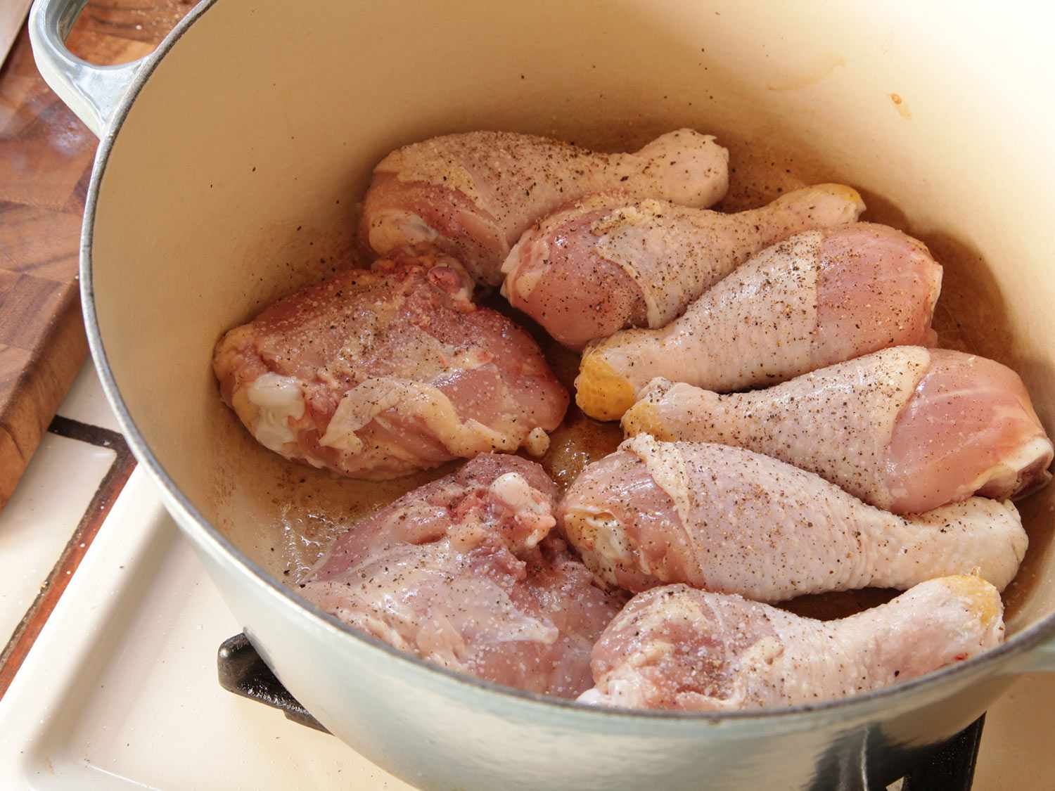 Browning bone-in chicken drumsticks and thighs in a Dutch oven for cassoulet.