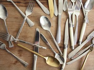 a bunch of silverware on a wooden surface