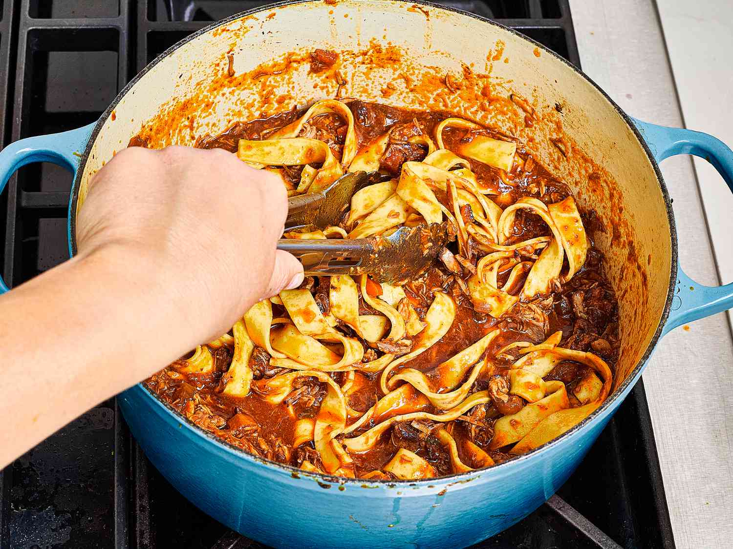 Mixing pasta into ragu