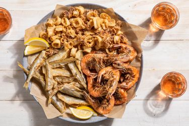 A large platter of fritto misto di mare with fried shrimp, squid, and smelt.