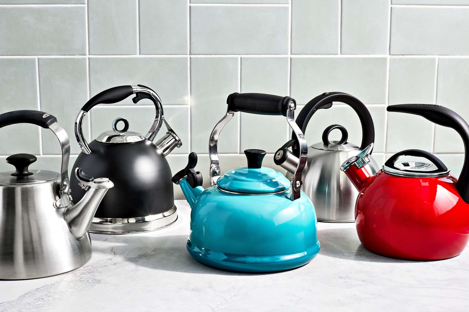 a group of stovetop kettles on a marble surface