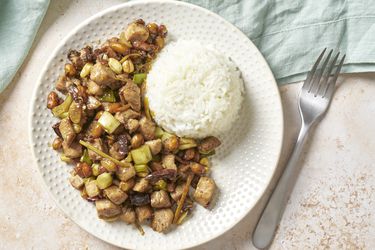 Gong bao ji ding chicken on a plate with white rice.