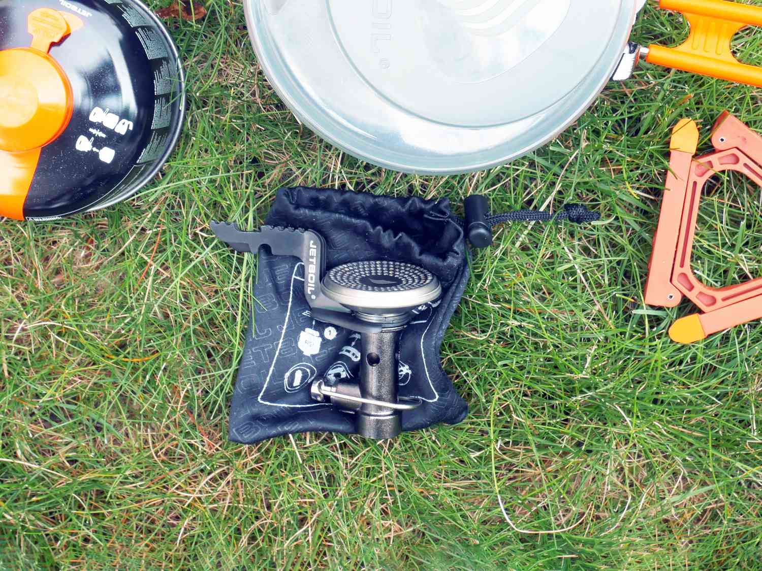 fuel, camping pot, camping stove and stand on grass