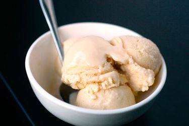 三勺新英格兰风格的香草冰淇淋，放在一个白色的碗里。