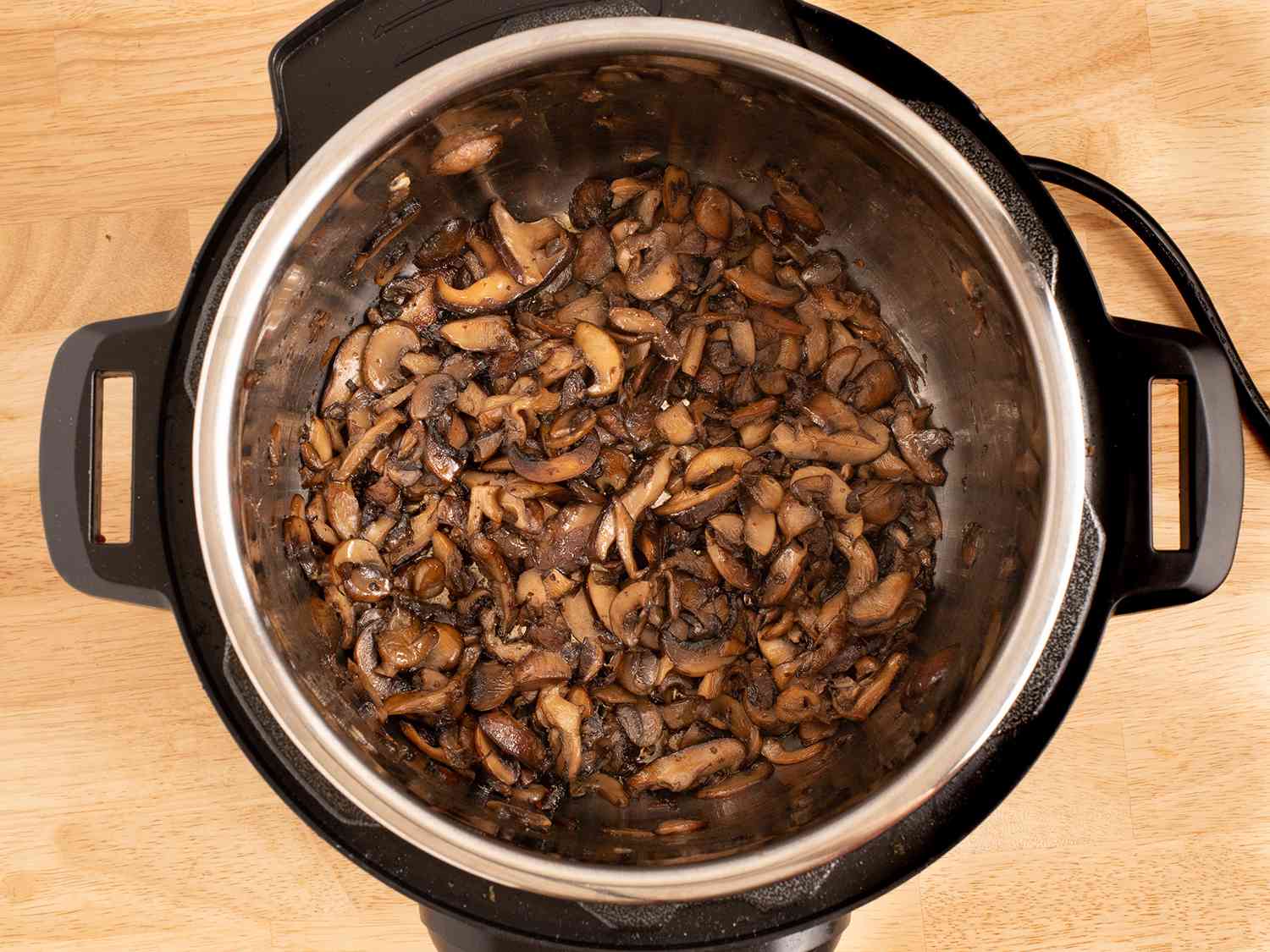 压力锅里的棕色蘑菇。
