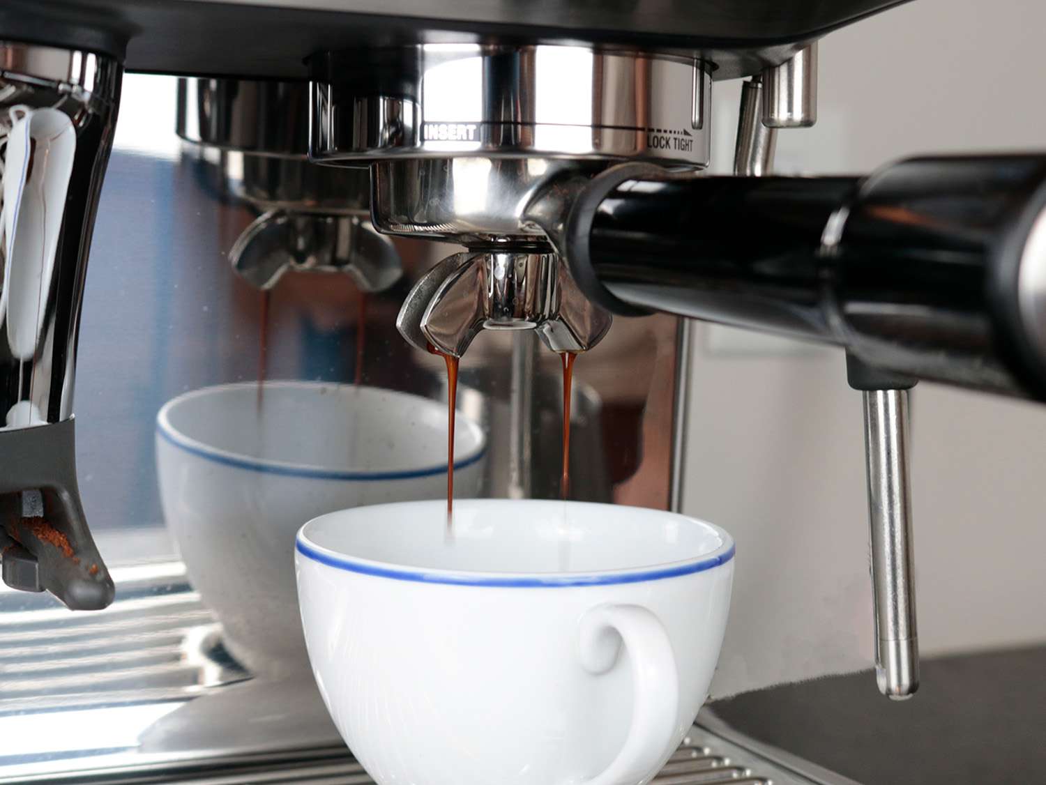 an espresso shot with thick streams is dropping into a cup