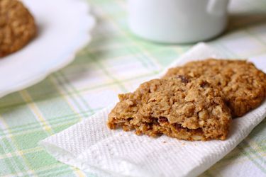 Gluten-free whole grain oatmeal cookies on a paper towel on a pastel plaid tablecloth.
