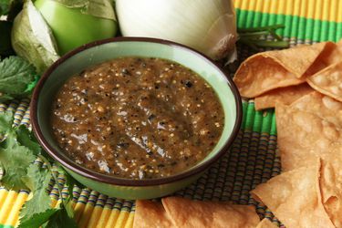 A bowl of charred salsa verde next to some tortilla chips.