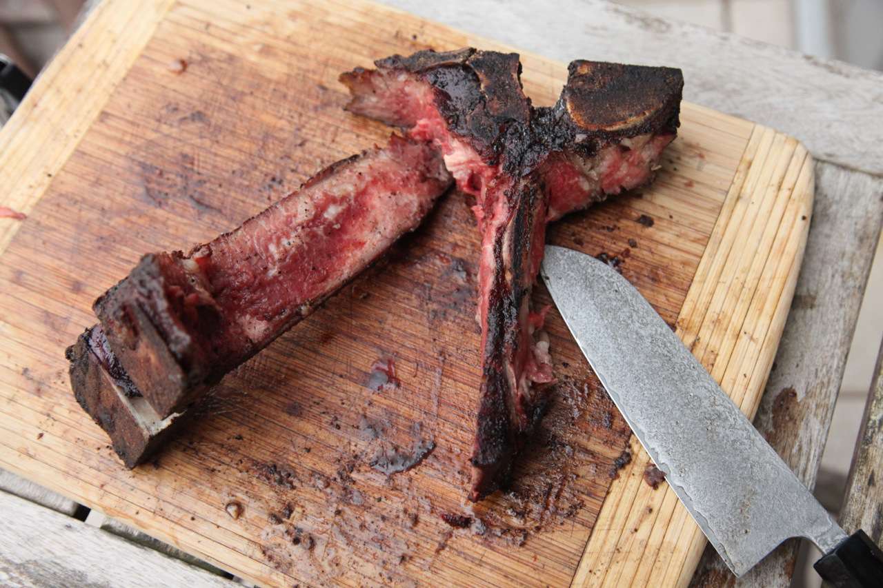 一块切菜板，上面有两个肉T骨。