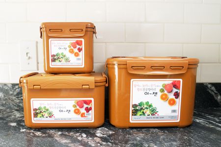 three sizes of fermentation containers on a marble countertop