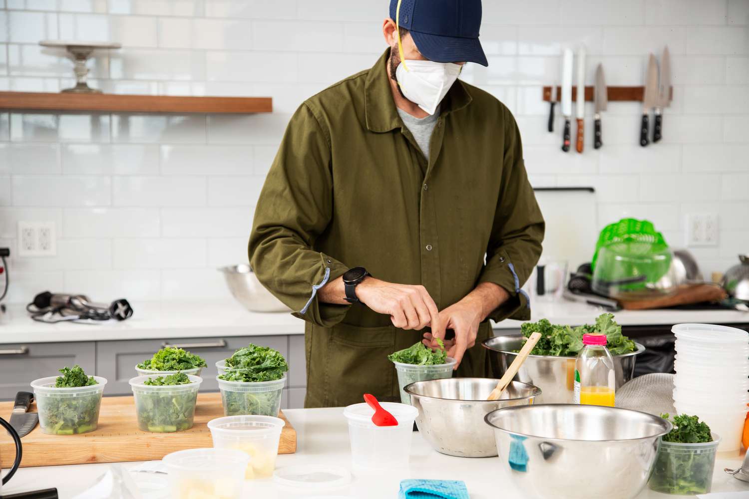 Portioning kale leaves into kale stems into deli containers