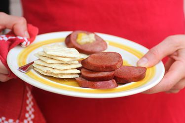 Someone holding a platter with Midwestern bologna and crackers.